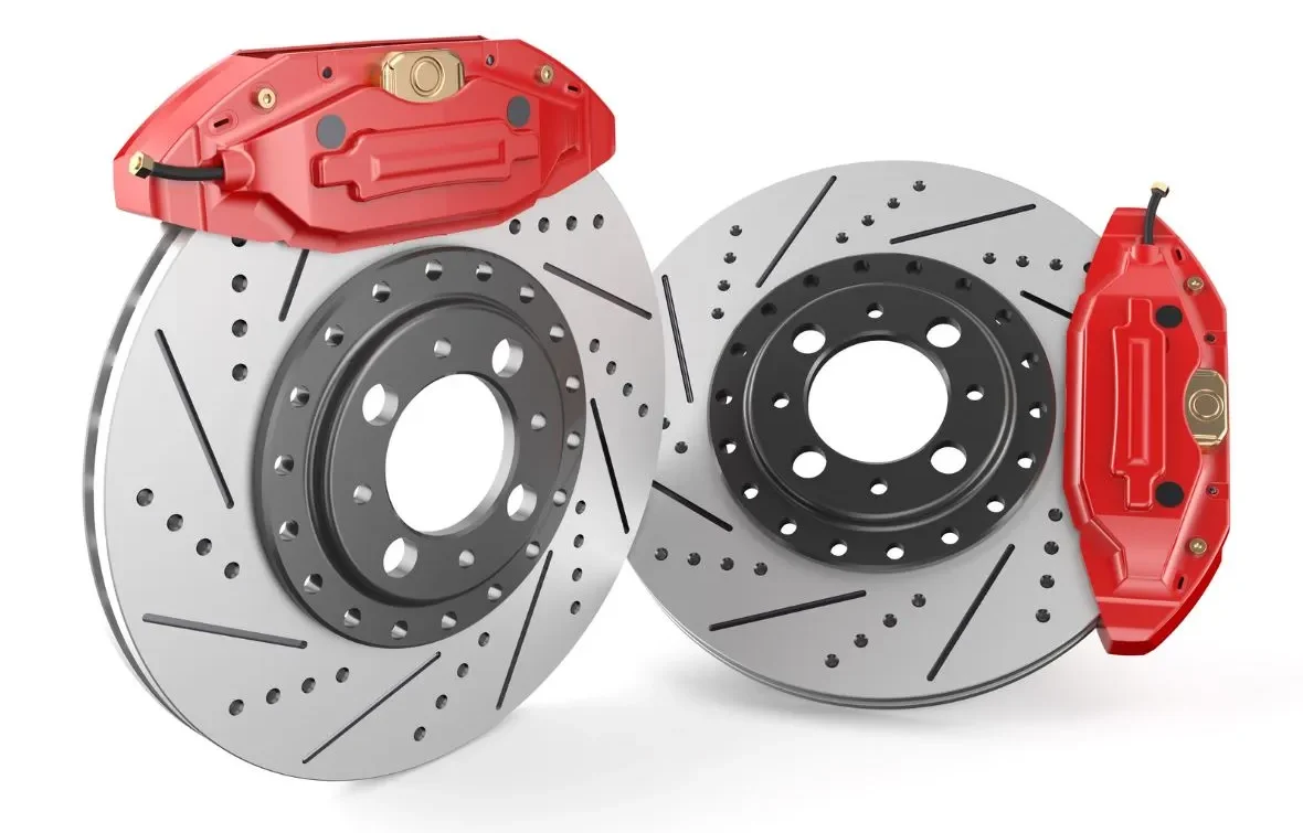 Two red brake calipers with drilled and slotted brake rotors, shown in a studio setting.